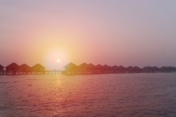 Naklejka premium Sunset at Maldives beach, luxury water lodges