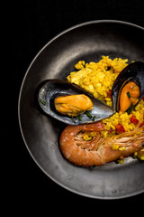 Traditional rice in paella with fish and meat.