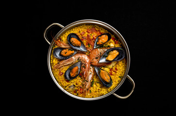 Traditional rice in paella with fish and meat.