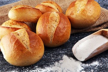 Different kinds of bread and bread rolls on board from above. Kitchen or bakery poster design