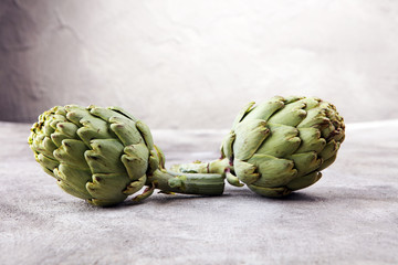 Fototapeta premium artichokes on grey background. fresh organic artichoke flower.