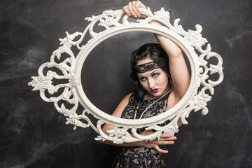 brunette girl in black dress in the style of the decadence in the frame of the photo