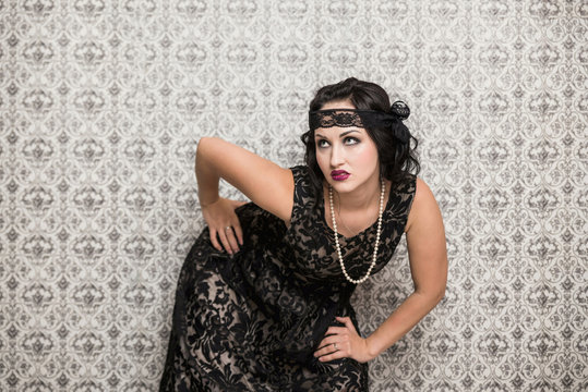 brunette girl in black dress in the style of decadence on a light background