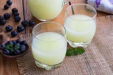 Two glasses of whey with blueberries in the background
