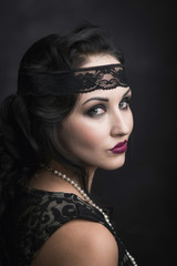 brunette girl in black dress in the style of decadence on a black background