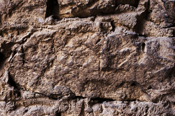 Close up Textured background of a wall of medieval stone masonry. The wall is sloppy built of mountain stones. Medieval style