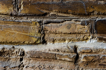 Close-up Textured background of old brick masonry pale yellow with deep horizontal scuffs. Grunge...