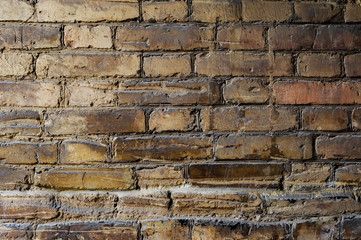 Textured background of old brick masonry pale yellow with deep horizontal scuffs. Grunge texture of the old brick coating deformed by horizontal impact