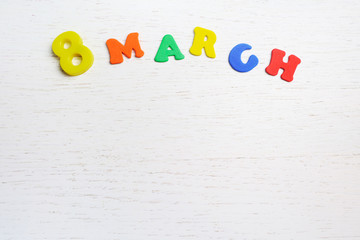 inscription on March 8 from colored letters on a white wooden background on a white wooden background