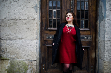 Brunette plus size model at red on street of city.