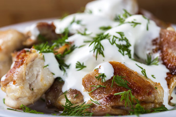 Fried chicken meat with sour cream and fresh green dill