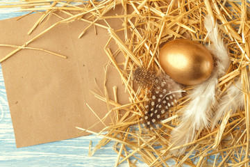 Nest with Easter eggs on blue wooden background, top view with copy space