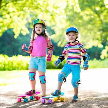 Children riding skateboard in summer park