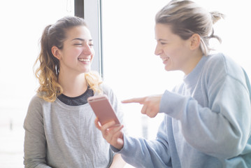 two Young woman in the gym with smartphone