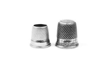 Two metal silver sewing thimbles on a white background. Sewing accessories and tools