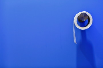 a roll of toilet paper on a blue wall