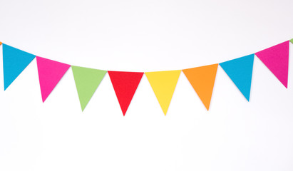 Fototapeta na wymiar Colorful hanging paper flags on white wall background, decor items for party, festival, celebrate event