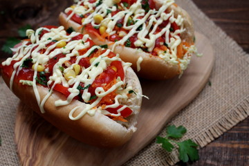 Hod dog with vegetables on wooden background. Top view.