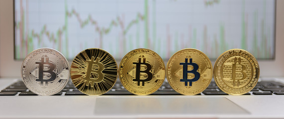  golden bitcoin on keyboard with chart on monitor