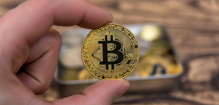  bitcoin holding in man&rsquo;s fingers