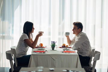 Happy couple at restaurant eating lunch.Talking over meal.Hotel full board,all inclusive stay.Travel, date,food,lifestyle.Smiling people having healthy breakfast.Food review.Manners at the table