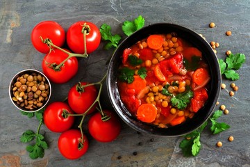 Homemade tomato, lentil soup, overhead scene, flat lay on a dark slate background
