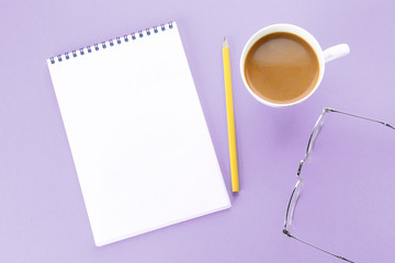 Top view image of open notebook with blank pages and coffee on blue background, ready for adding or mock up. Still life, business, office supplies or education concept.