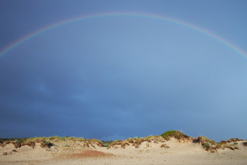 Rainbow at the beach with rain in salento - Italy