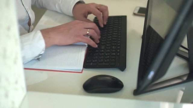 Close-up of hands typing on a keyboard in an home office
