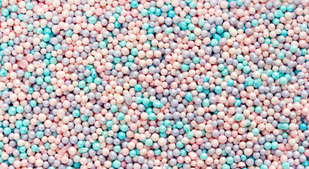 Edible pastel color confetti sprinkles for cake cookie ice cream decoration as a background