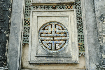 window with the longevity symbol inside the complex of the mausoleum of the emperor Tu Duc in Hue, Vietnam.
