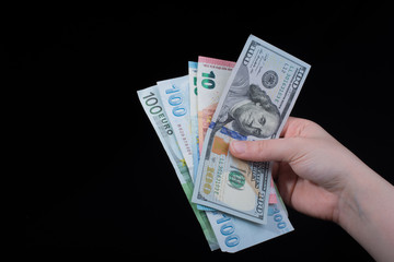 Hand holding American dollar  isolated on black background