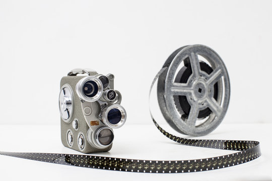 old movie camera with film reel on white background