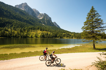 Bicyclists riding along mountain lake