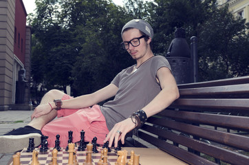 Young man playing chess in the park