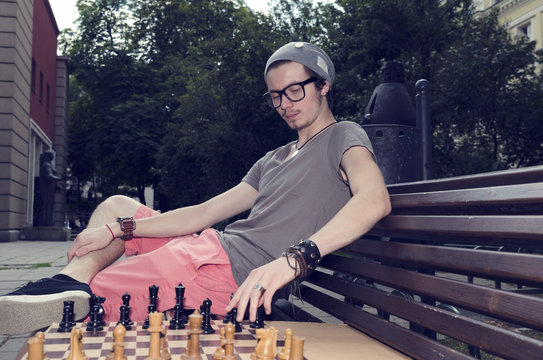 Young Man Playing Chess In The Park