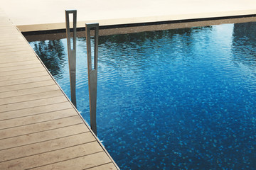 Fototapeta na wymiar Swimming pool with teak wood floor stripes summer vacation