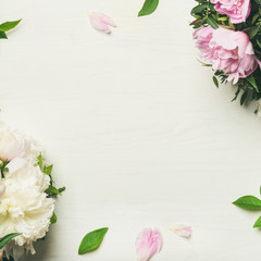 Spring flowers layout. Flat-lay of tender pale pink and white peonies over white background, top...