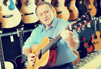 Obraz premium Man is playing on acoustic guitar