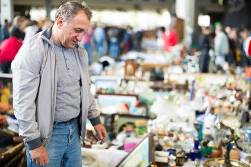 Smiling middle aged man buying retro handicrafts
