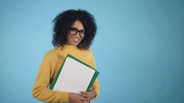 Smiling african student with folders showing OK sign. Mixed race girl in glasses, international education and people concept, 4k