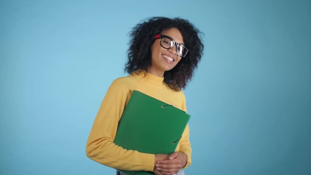 Smiling african student with folders showing thumbs up. Mixed race girl in glasses, international education and people concept, 4k