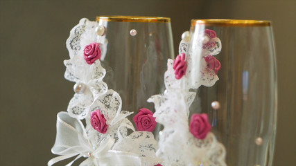 Close up champagne glasses with pink champagne and gold sugar on the rim. Video. Glasses for a wedding on a gray background