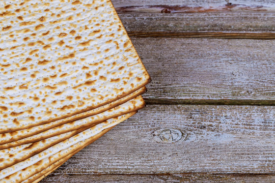 Closeup of Passover Matzah background matzoh over wooden table.