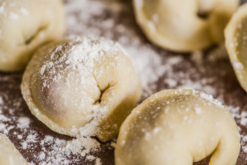 dumplings in raws on a wooden table covered with flour
