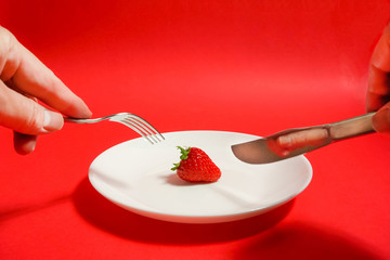A strawberry and fork, Strawberry of the dessert　フォークとイチゴ、デザートのイチゴ、レストランのイチゴなど　赤色背景