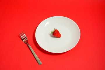 A strawberry and fork, Strawberry of the dessert　フォークとイチゴ、デザートのイチゴ、レストランのイチゴなど　赤色背景