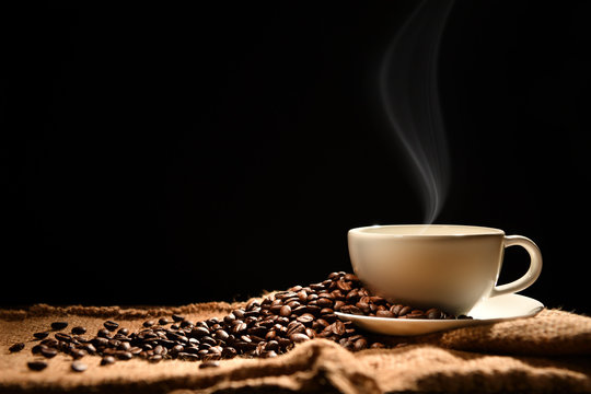 Fototapeta Cup of coffee with smoke and coffee beans on black background, This image with no smoke is available