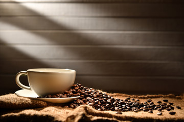 Coffee cup and coffee beans on old wooden background