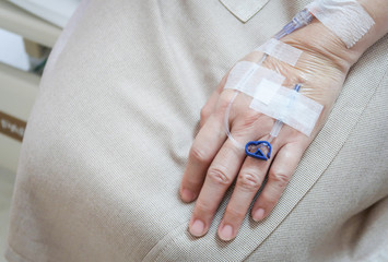 Patient's hand with drip receiving a saline solution.